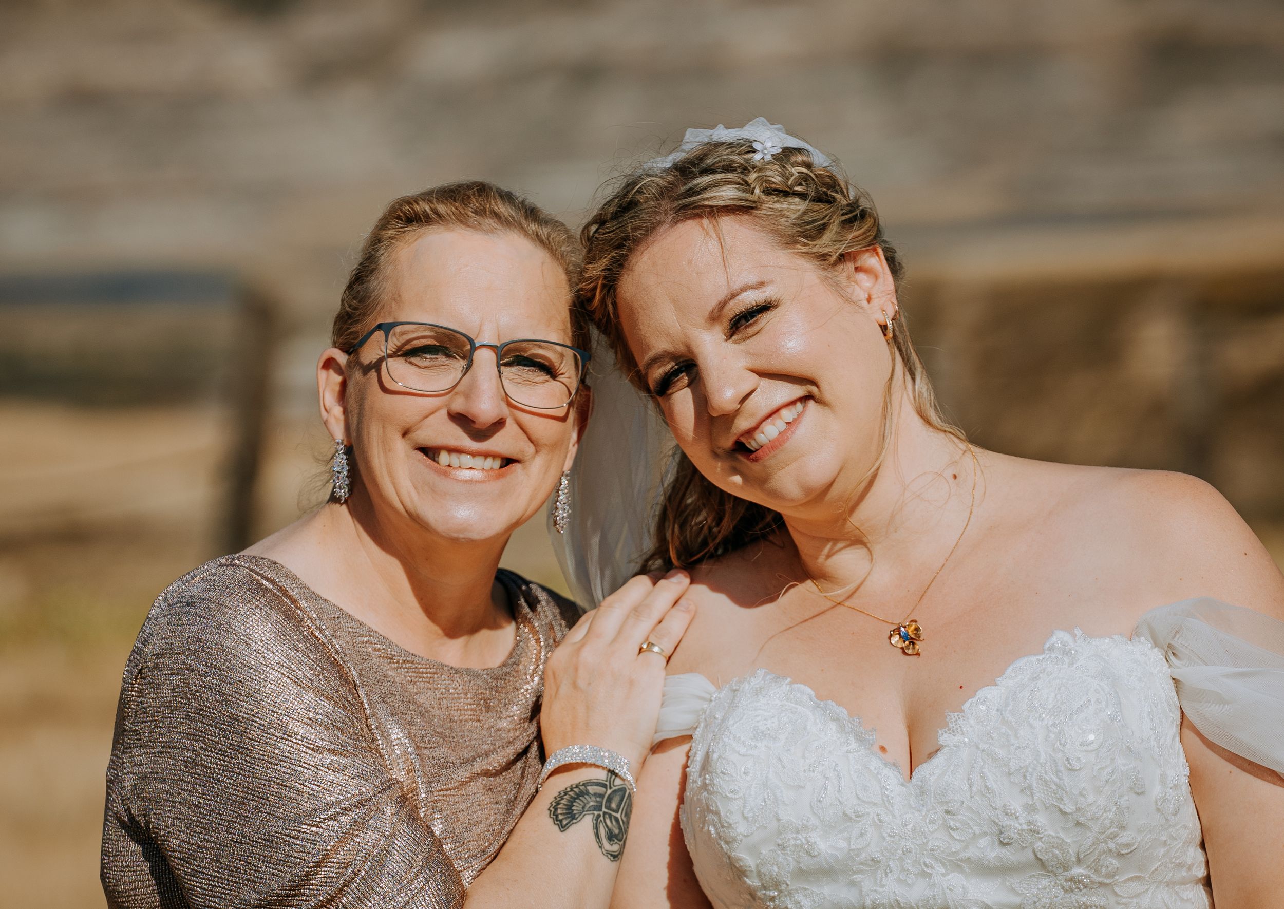 Close-up portrait with joyful expressions against a sunny outdoor backdrop.