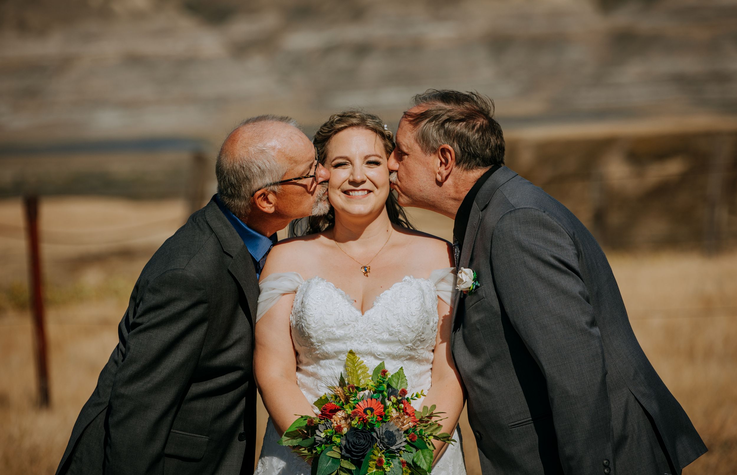 Sweet moment captured during outdoor wedding ceremony with desert landscape backdrop.