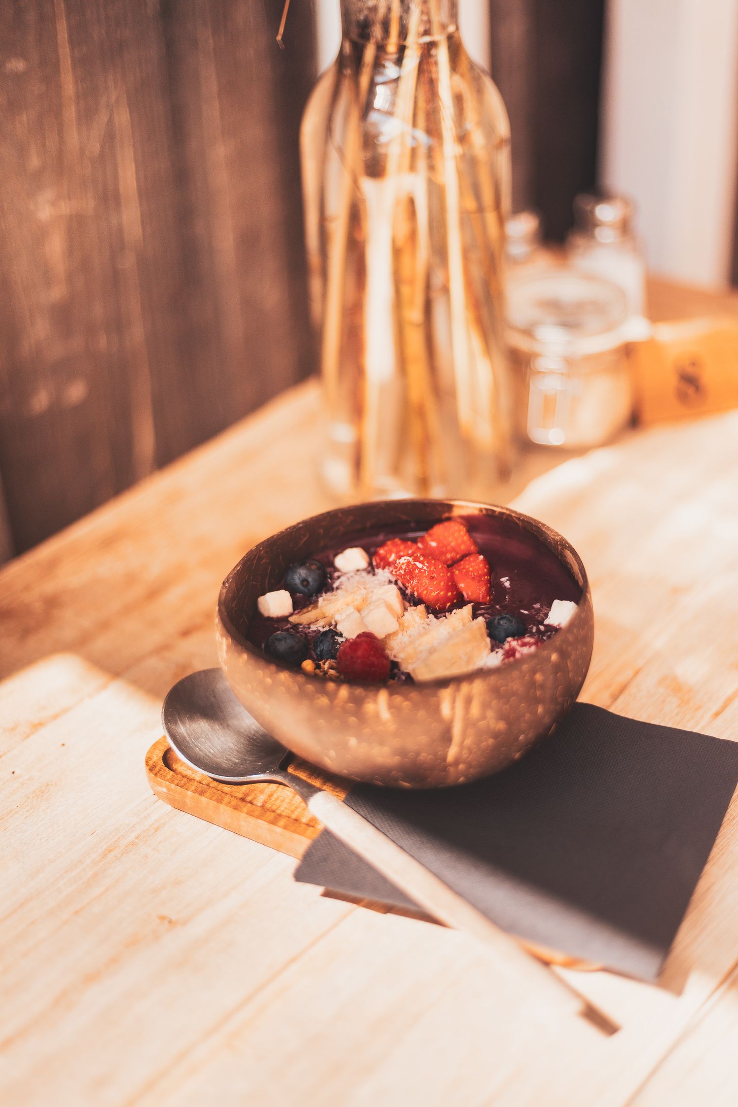 Chocolate dessert bowl garnished with fresh berries on wooden table.