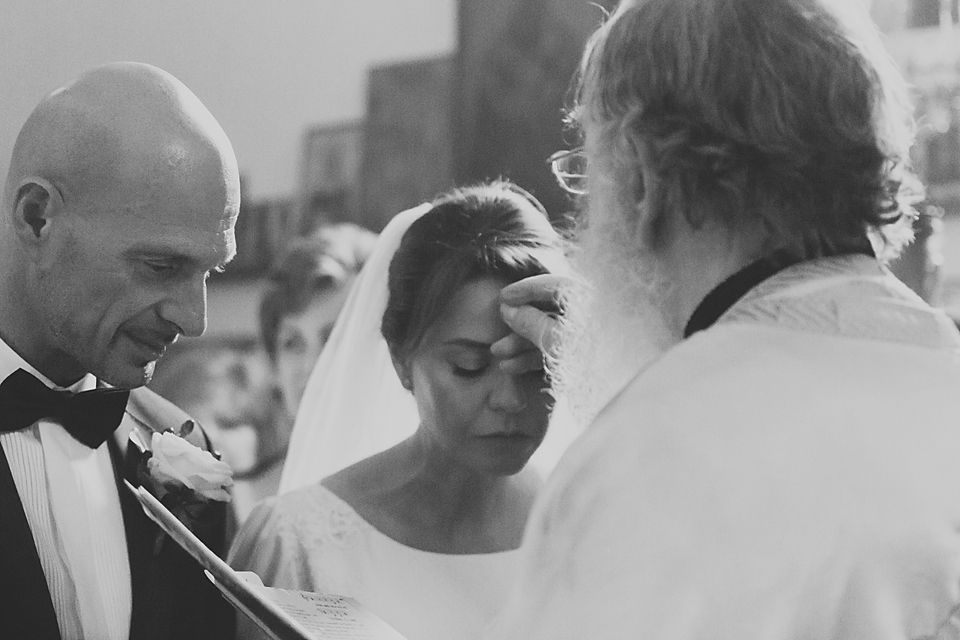Candid black and white photo capturing joyful laughter at a wedding reception.