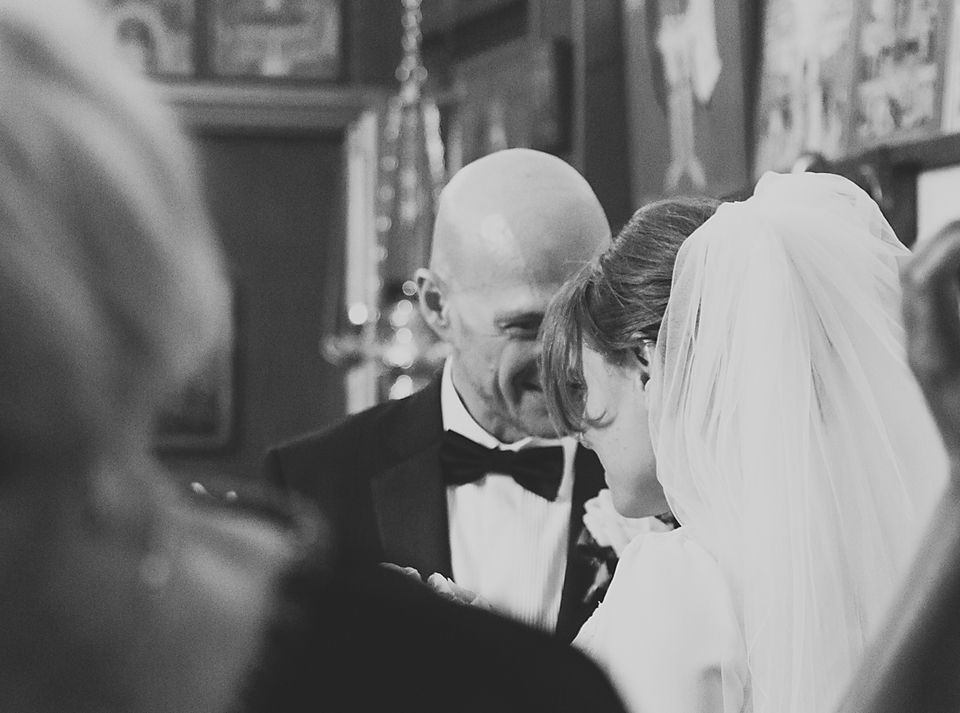 Black and white wedding photo showing guests mingling during the reception.