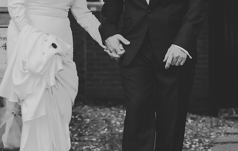 Black and white photo showing formal wedding attire details.