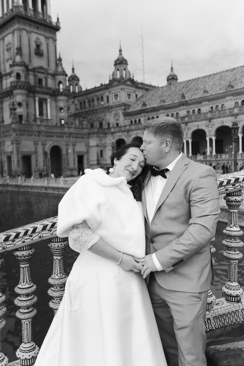A romantic wedding photo sequence showing a couple embracing at a historic Spanish colonial plaza with ornate architecture.