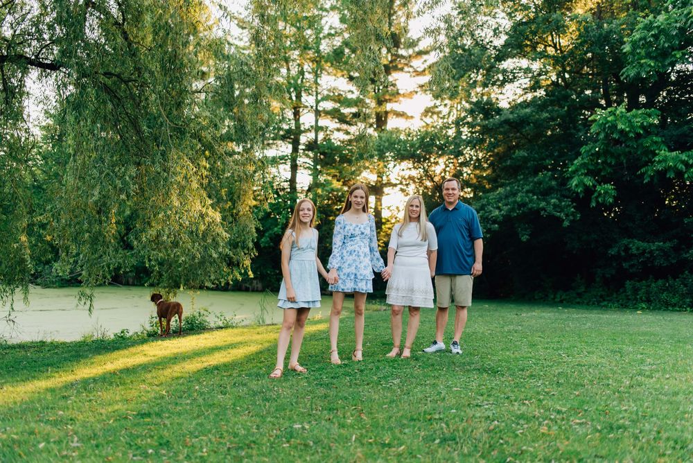 Family walking in the summer sun by pond