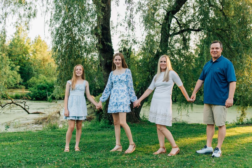 Family holding hands in front of pond at Succop Nature Park in Butler, PA