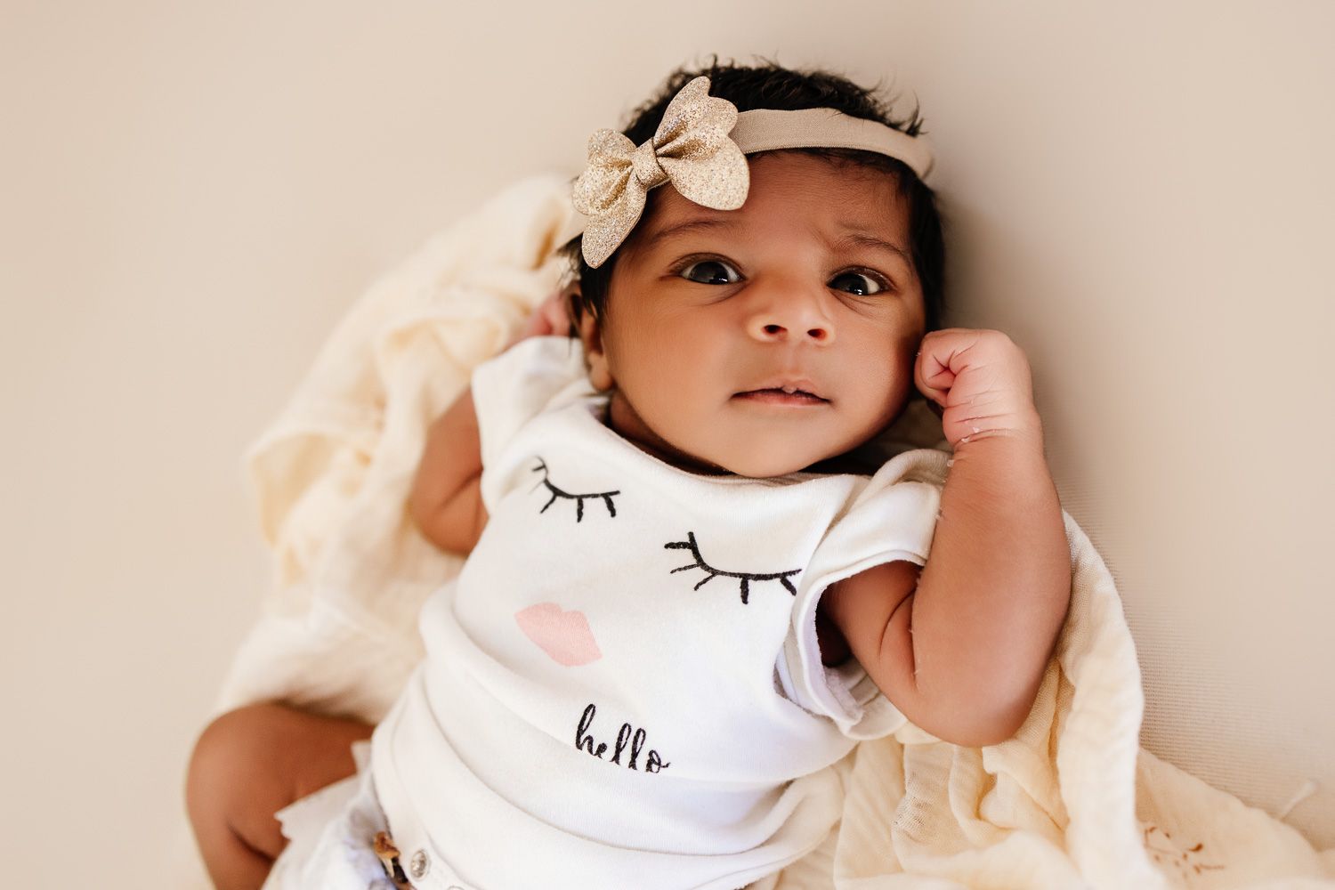A one week old baby looks into the camera during her newborn photoshoot in San Jose
