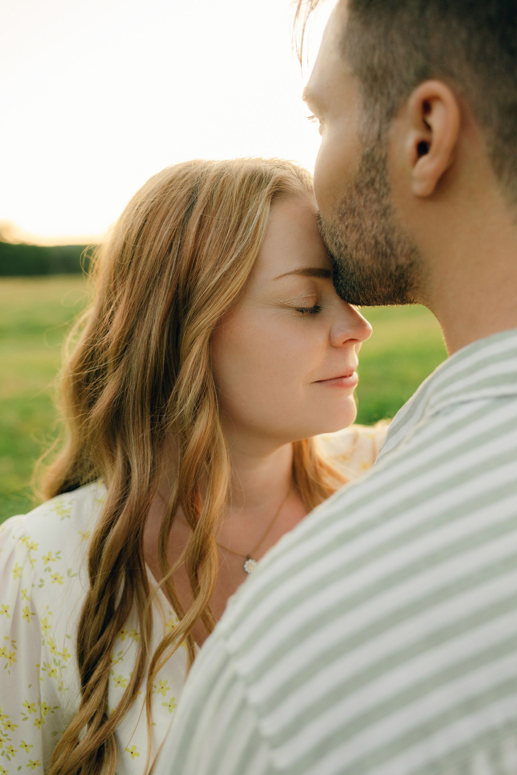 Parfotografering med Martina och Sebastian i Borgvik utanför Karlstad. han kysser henne på pannan.