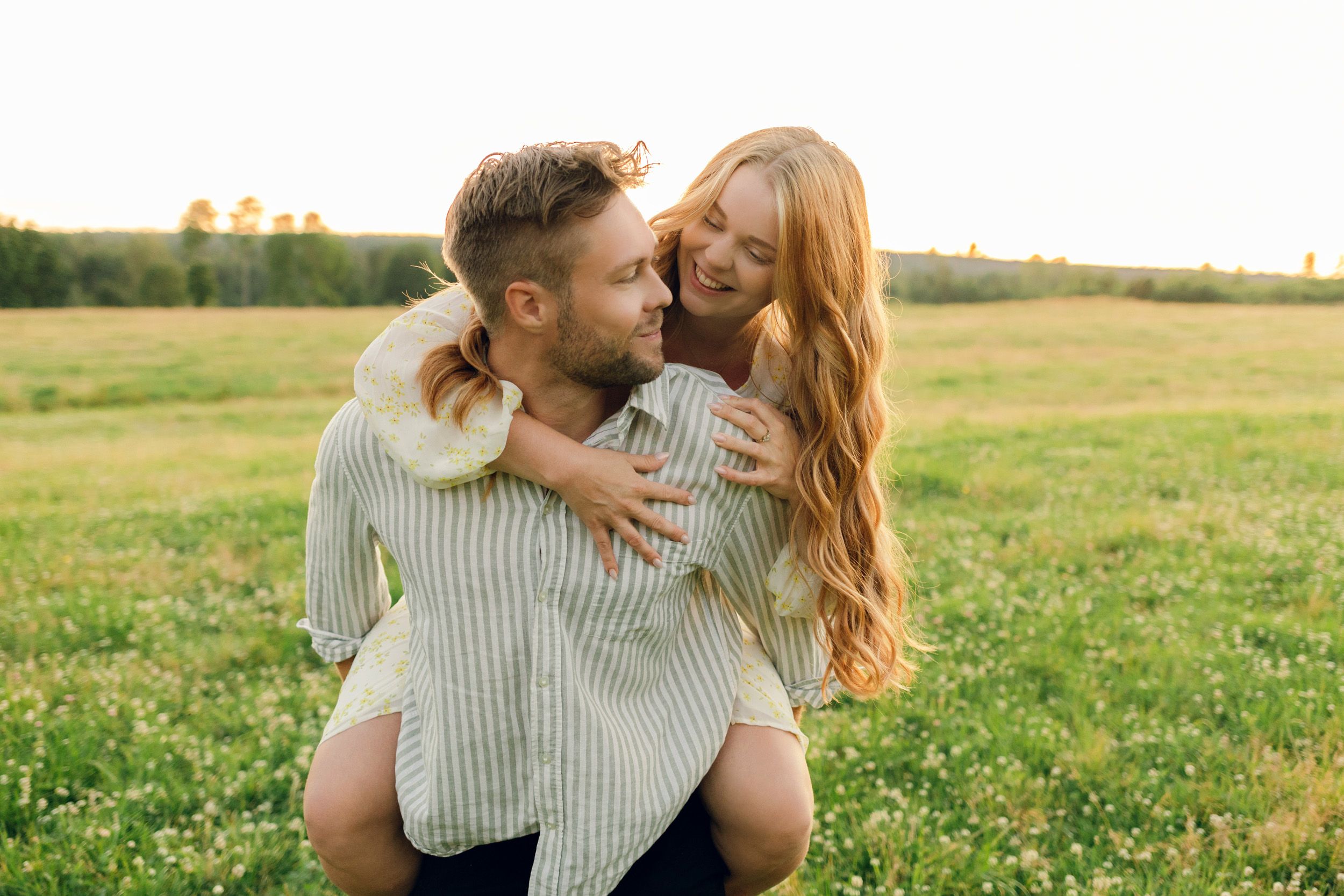 Parfotografering med Martina och Sebastian i Borgvik utanför Karlstad. Hon sitter på hans rygg och tittar ner mot honom.