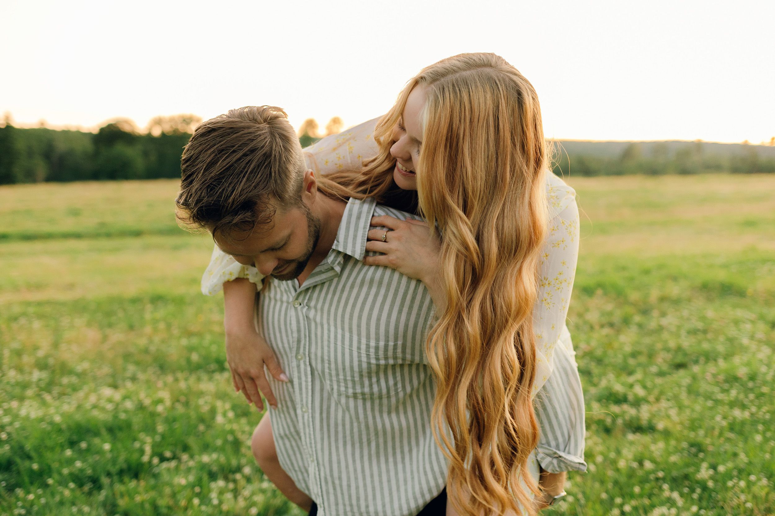 Parfotografering med Martina och Sebastian i Borgvik utanför Karlstad. Hon sitter på hans rygg och tittar ner mot honom.
