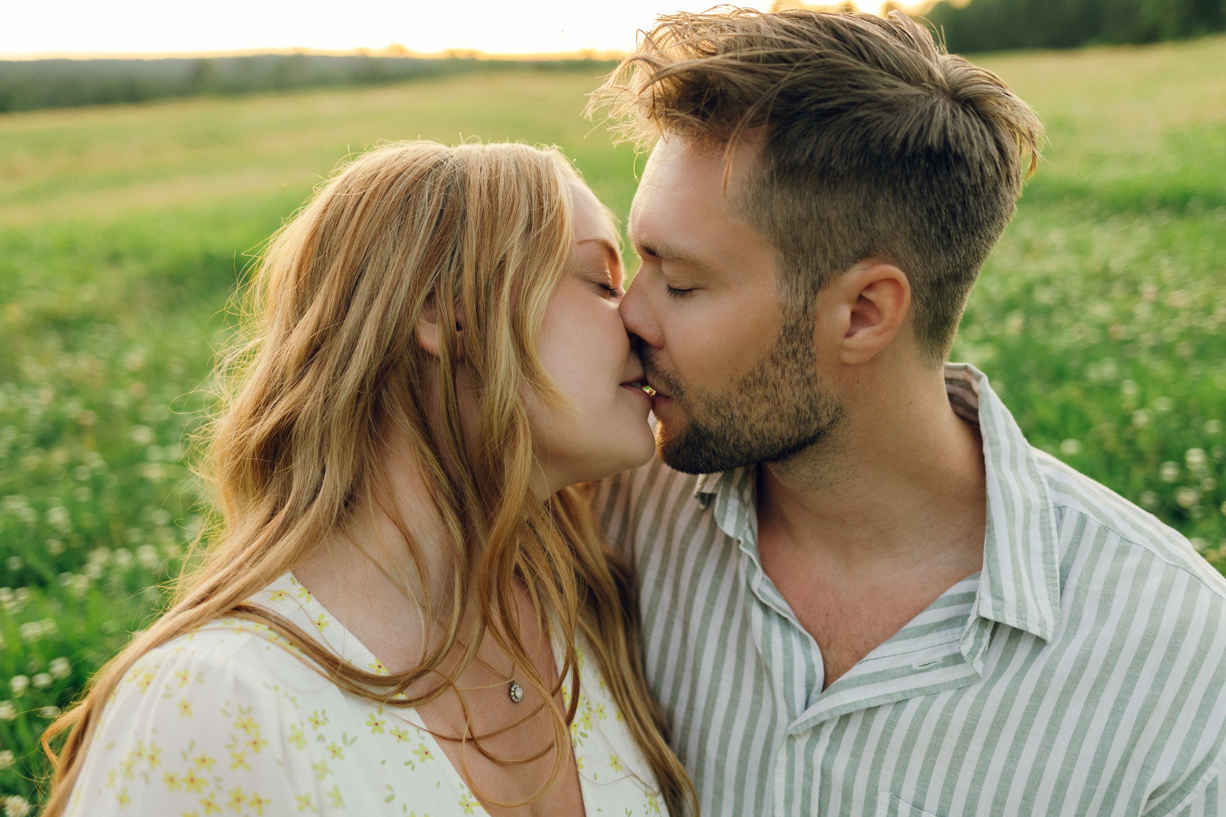 Parfotografering med Martina och Sebastian i Borgvik utanför Karlstad. Sitter på en filt tillsammans på ängen. Lutar in mot varandra.