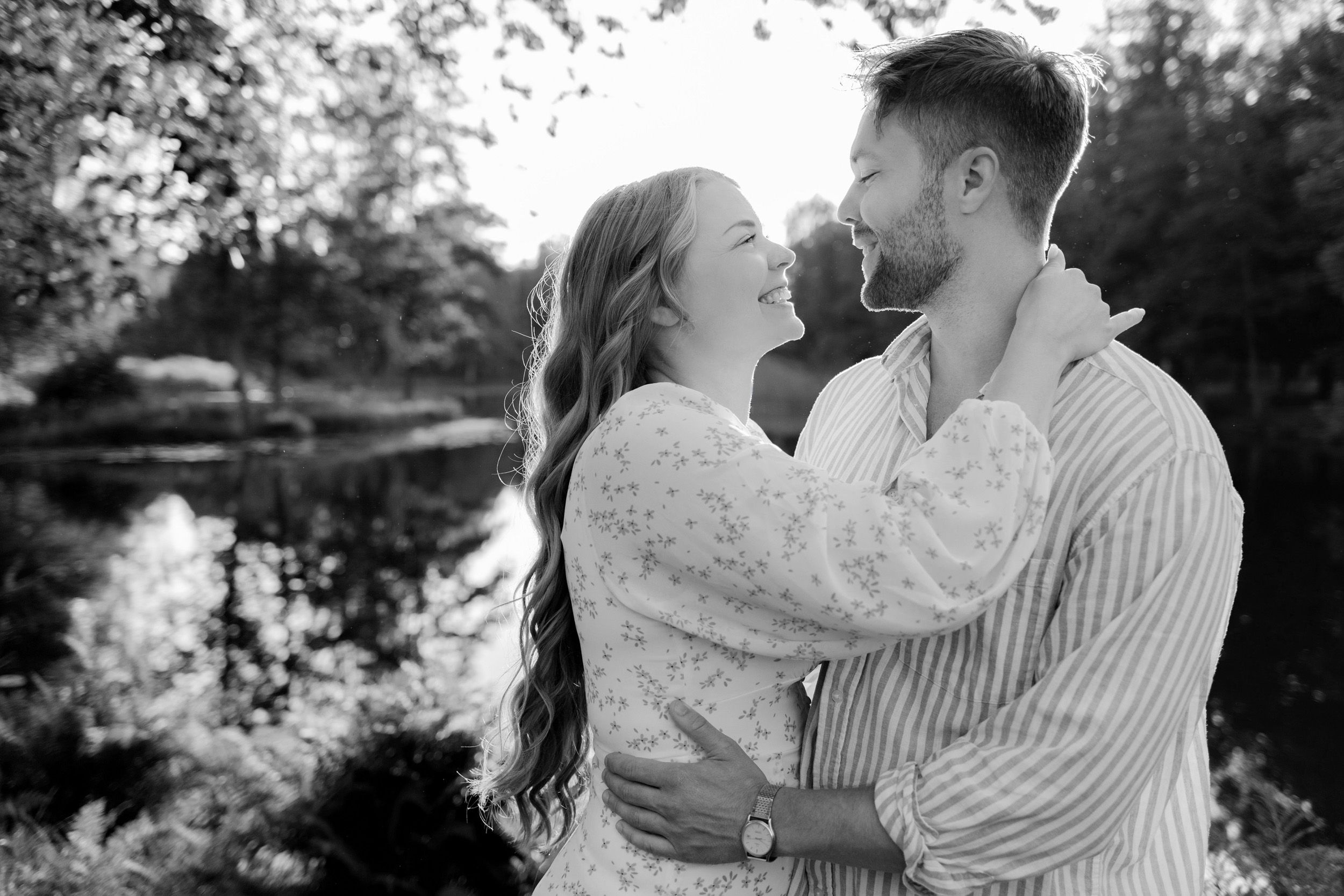 Parfotografering med Martina och Sebastian i Borgvik utanför Karlstad. De skrattar tillsammans. Svartvit bild.