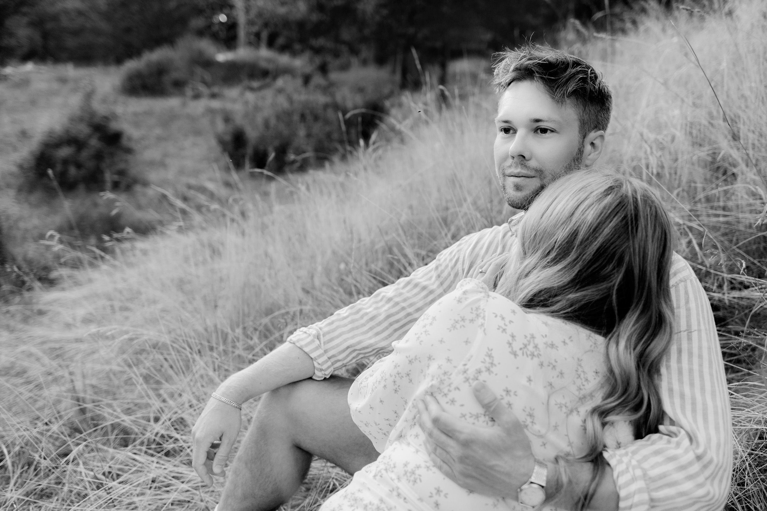 Parfotografering med Martina och Sebastian i Borgvik utanför Karlstad. Närbild på honom på kulle med högt gräs.