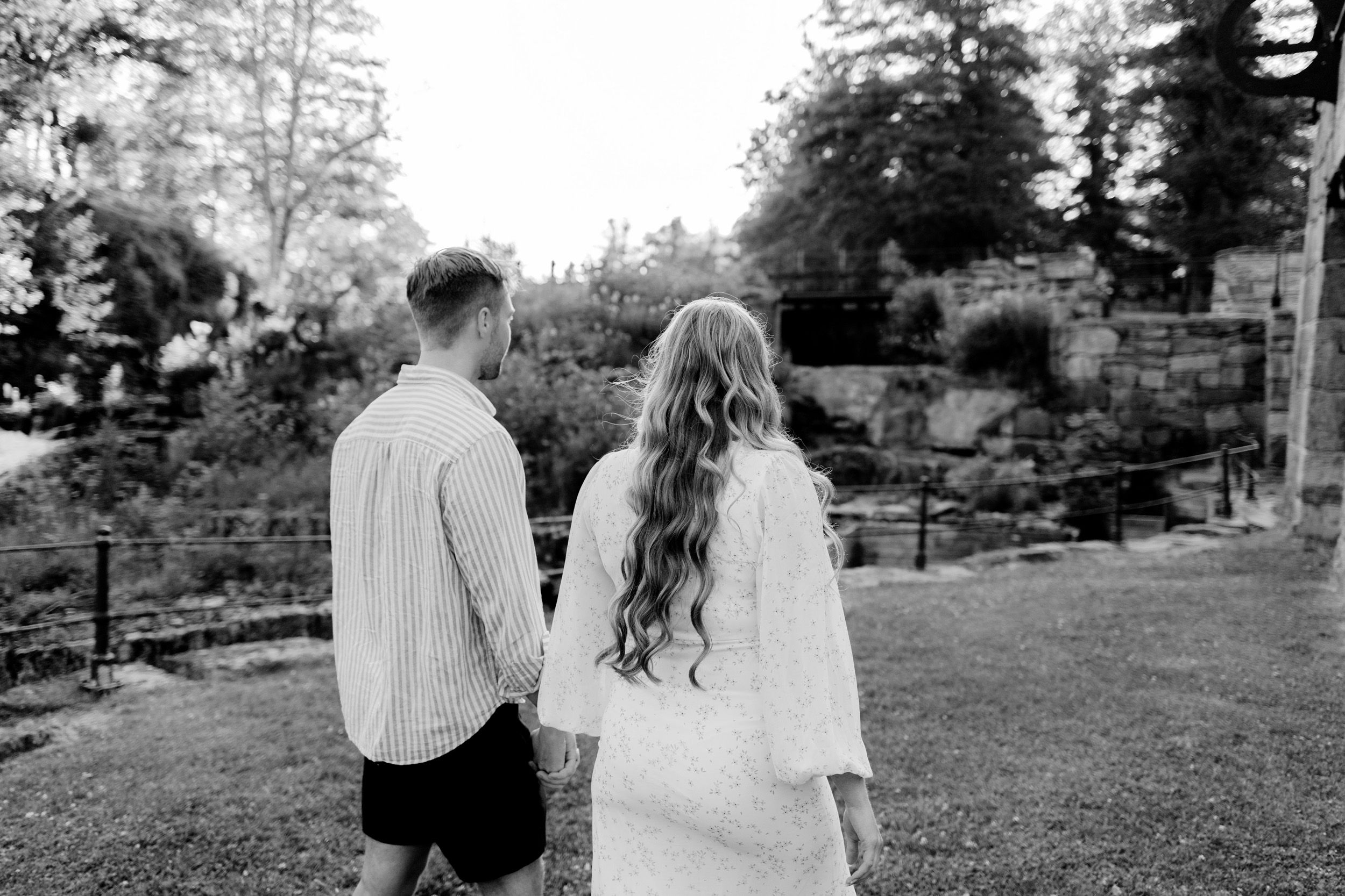 Parfotografering med Martina och Sebastian i Borgvik utanför Karlstad. Fotograf Rebecca Nordin. Gående hand i hand bakifrån.