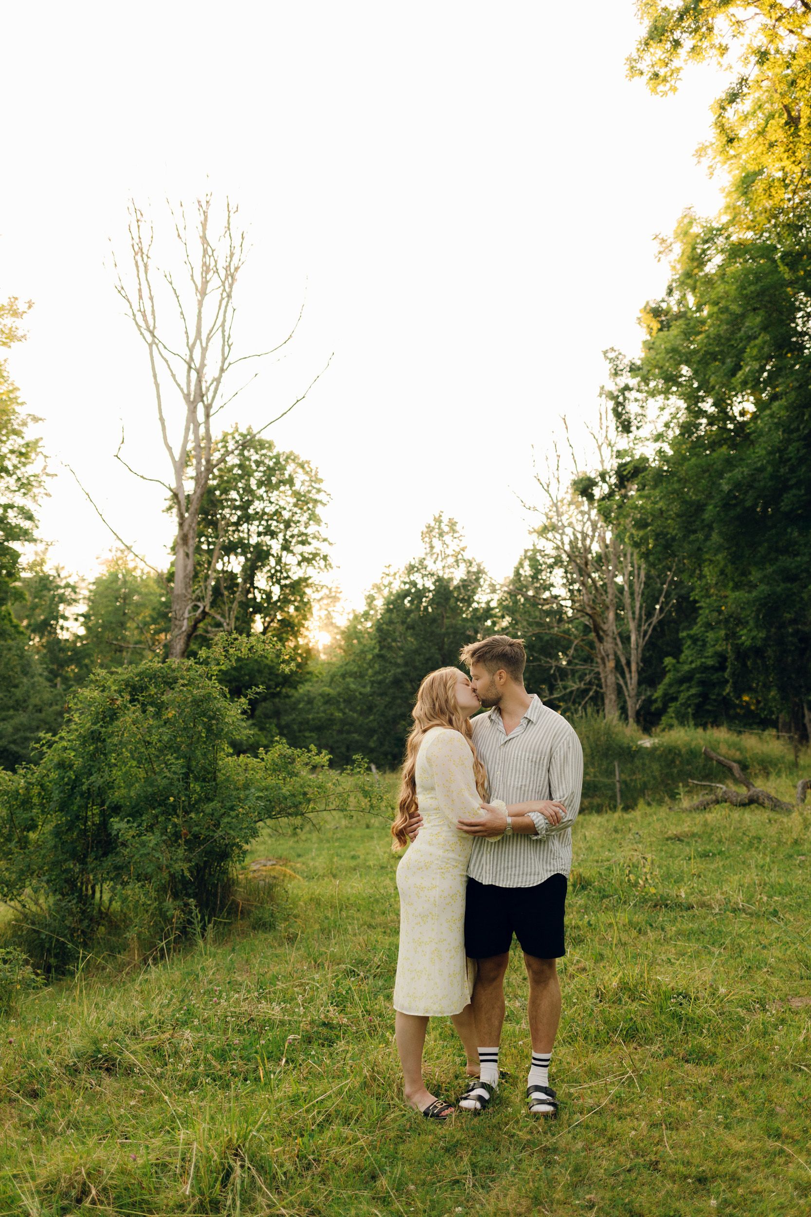 Parfotografering med Martina och Sebastian i Borgvik utanför Karlstad. Bild på avstånd när de håller om varandra i hagen.