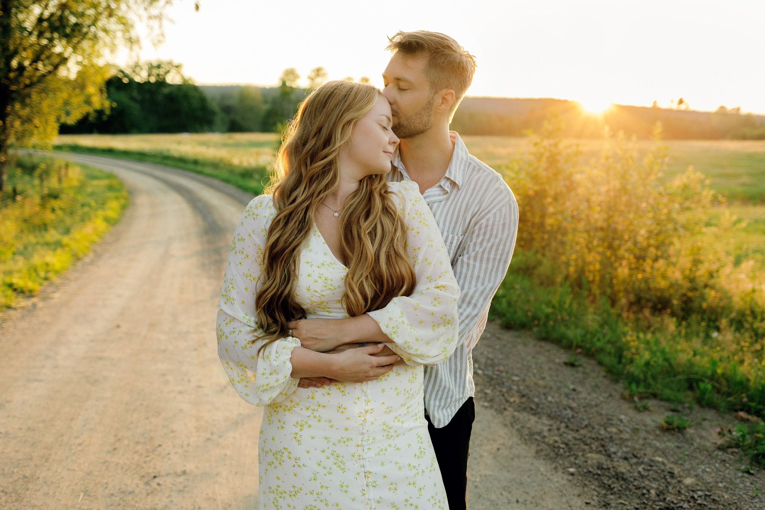 Parfotografering med Martina och Sebastian i Borgvik utanför Karlstad. Stående på grusväg i solnedgång. Han står bakom henne.