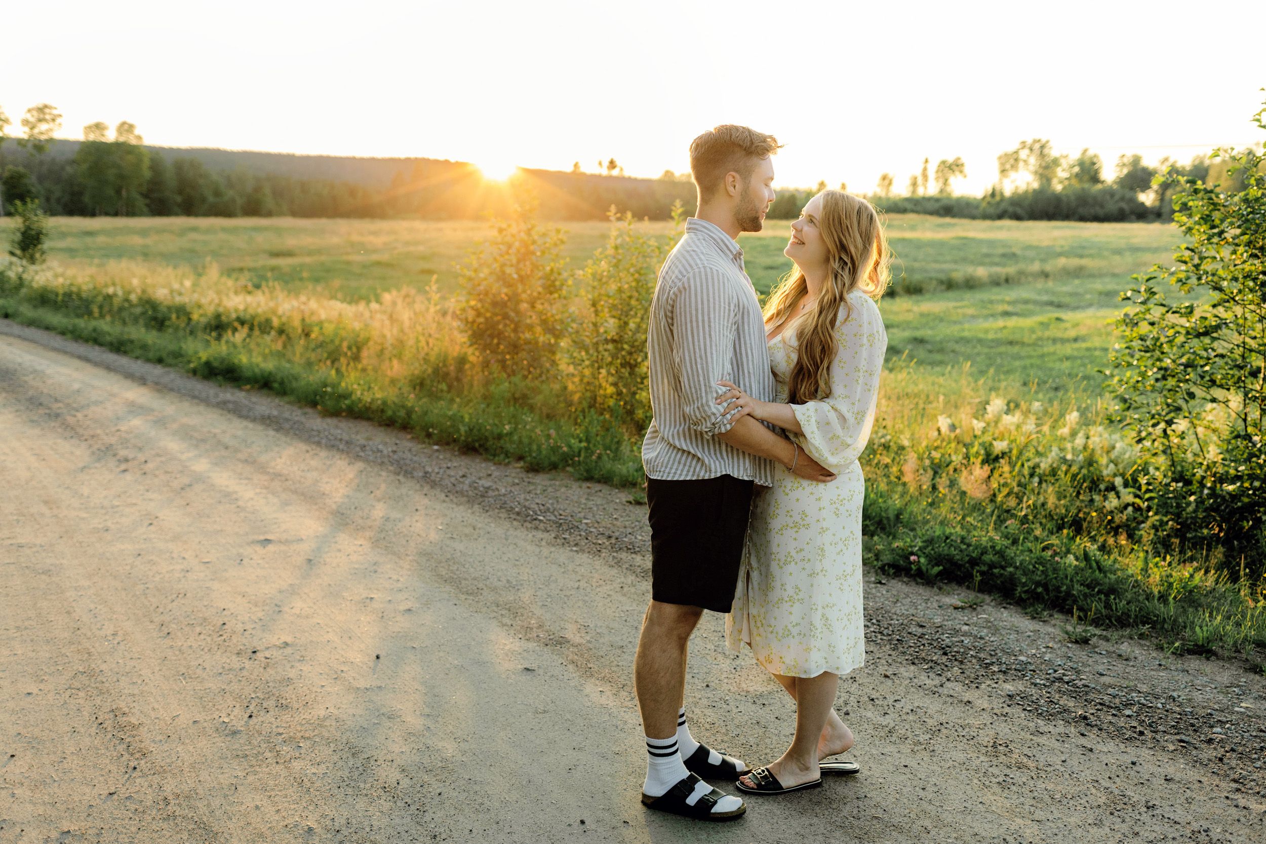 Parfotografering med Martina och Sebastian i Borgvik utanför Karlstad. Stående på grusväg i solnedgång.