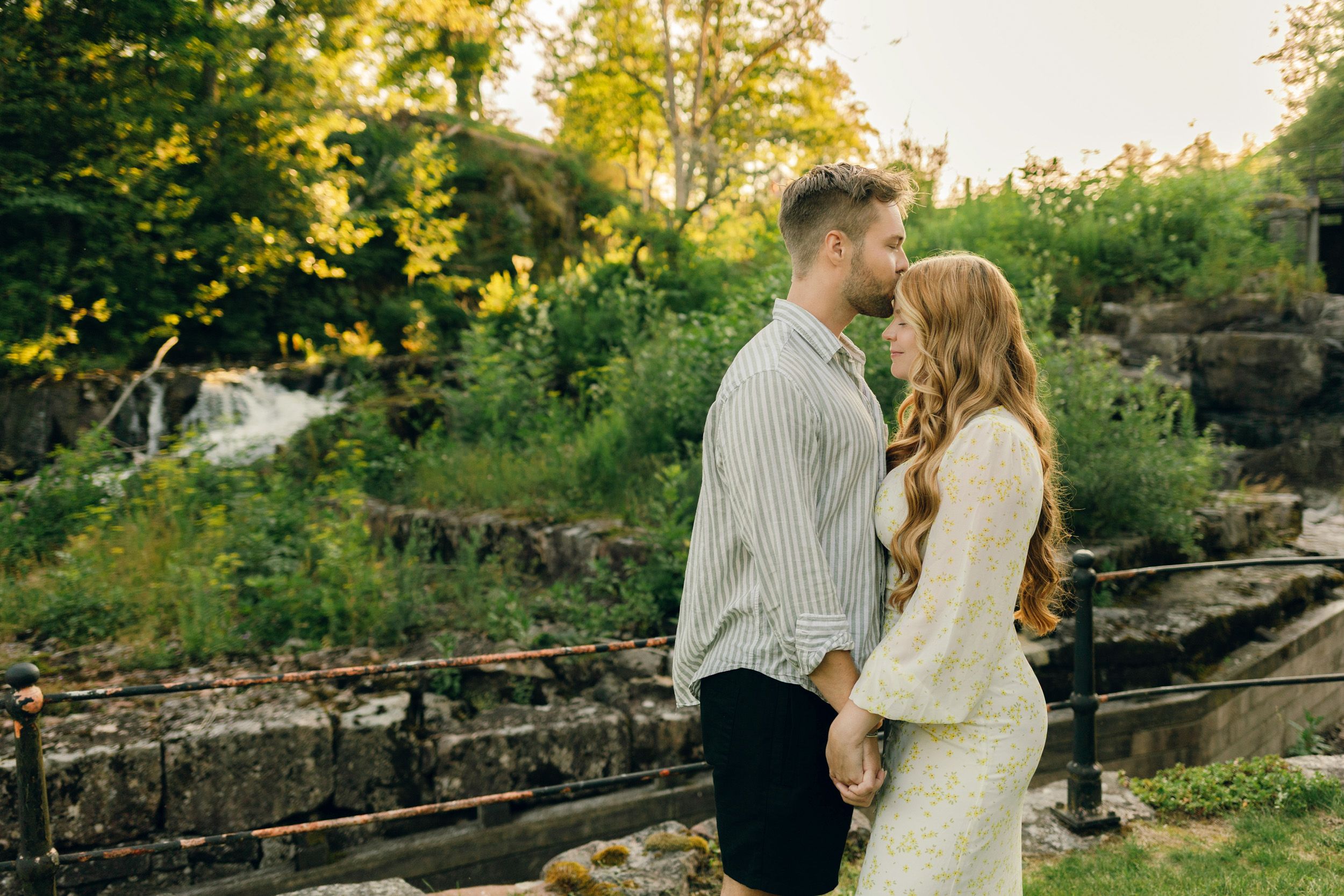 Parfotografering med Martina och Sebastian i Borgvik utanför Karlstad. Fotograf Rebecca Nordin. Han pussar henne på pannan,