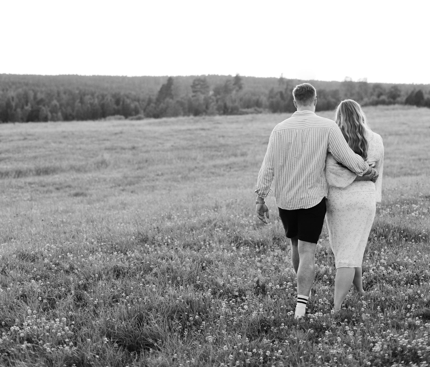 Parfotografering med Martina och Sebastian i Borgvik utanför Karlstad. Håller om varandra och går bortåt.