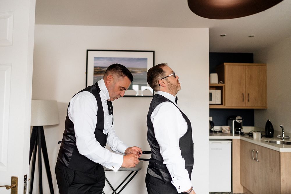 A series of black and white photos showing someone adjusting and styling a formal suit jacket and tie.