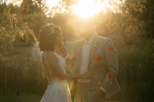 A romantic sunset wedding portrait with golden light filtering through trees.