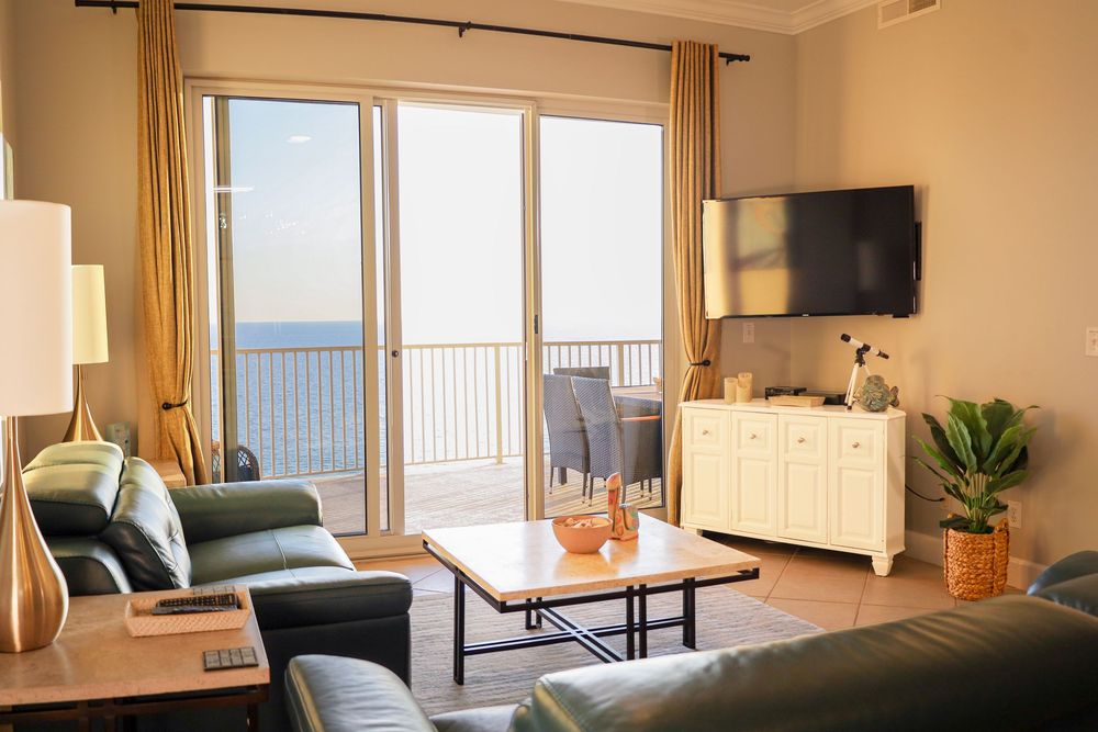 Bright and spacious beachfront condo interior with large windows, modern furnishings, and ocean views.