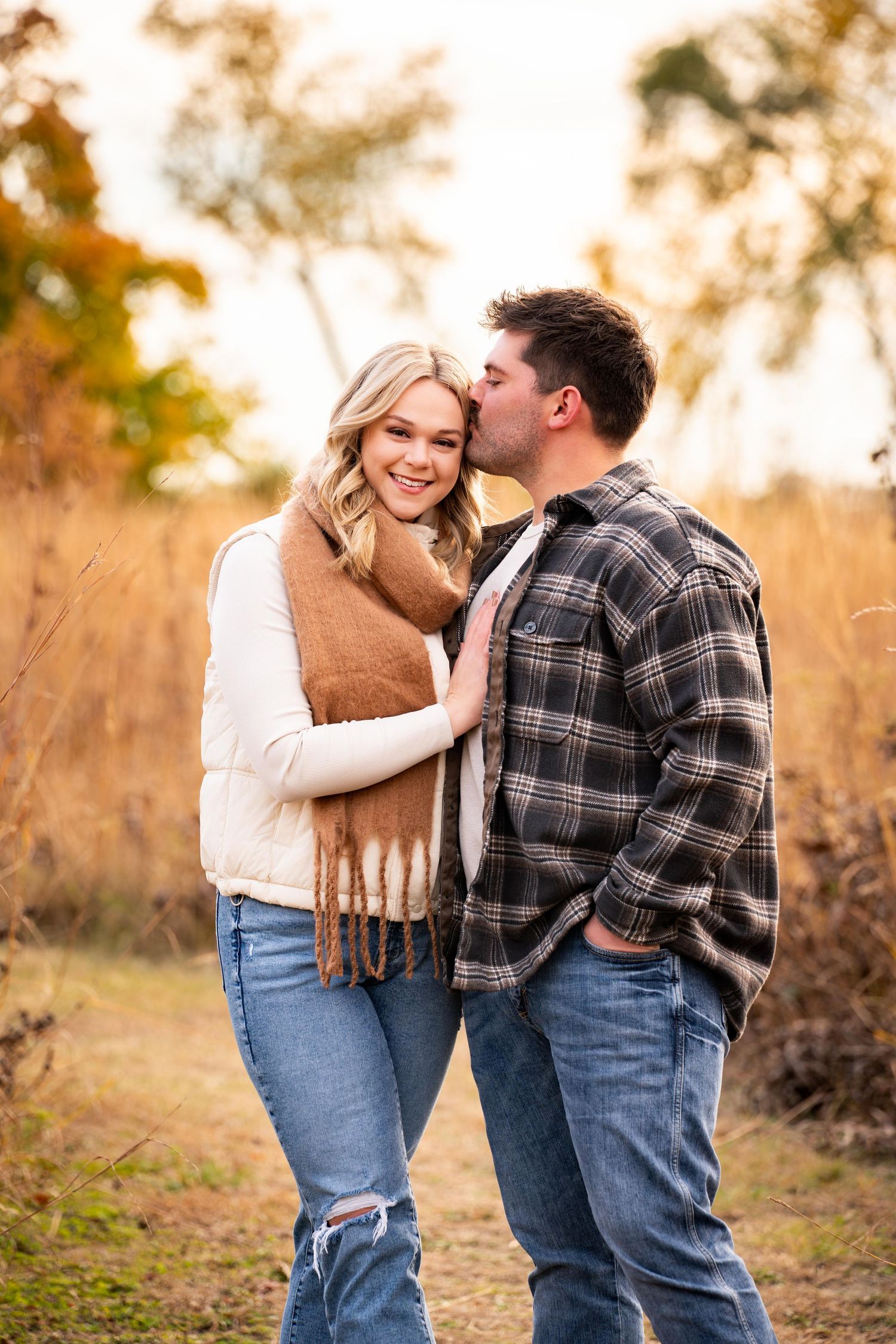 Couple in casual wear sharing romantic moment in autumn field.