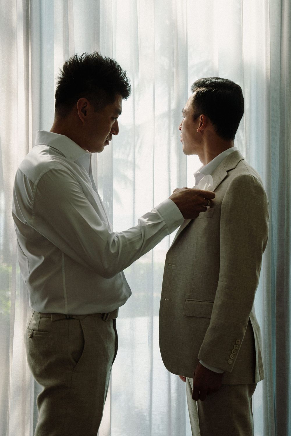 A series of four similar poses showing two people in white and beige formal attire standing close together.