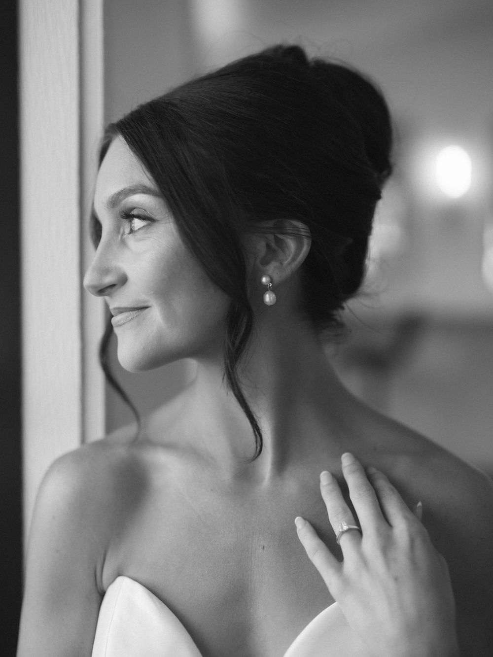 A black and white portrait series showing an elegant updo hairstyle and jewelry from different side angles.