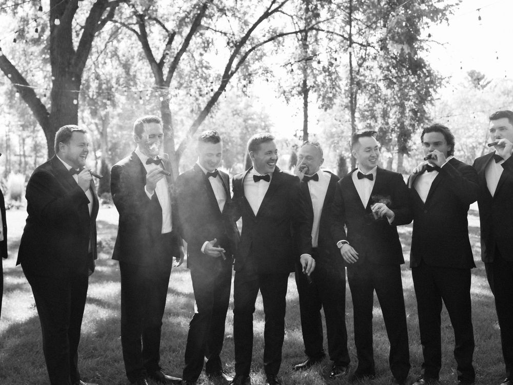 A black and white panoramic photograph shows a large group of people in formal attire standing in a line outdoors.