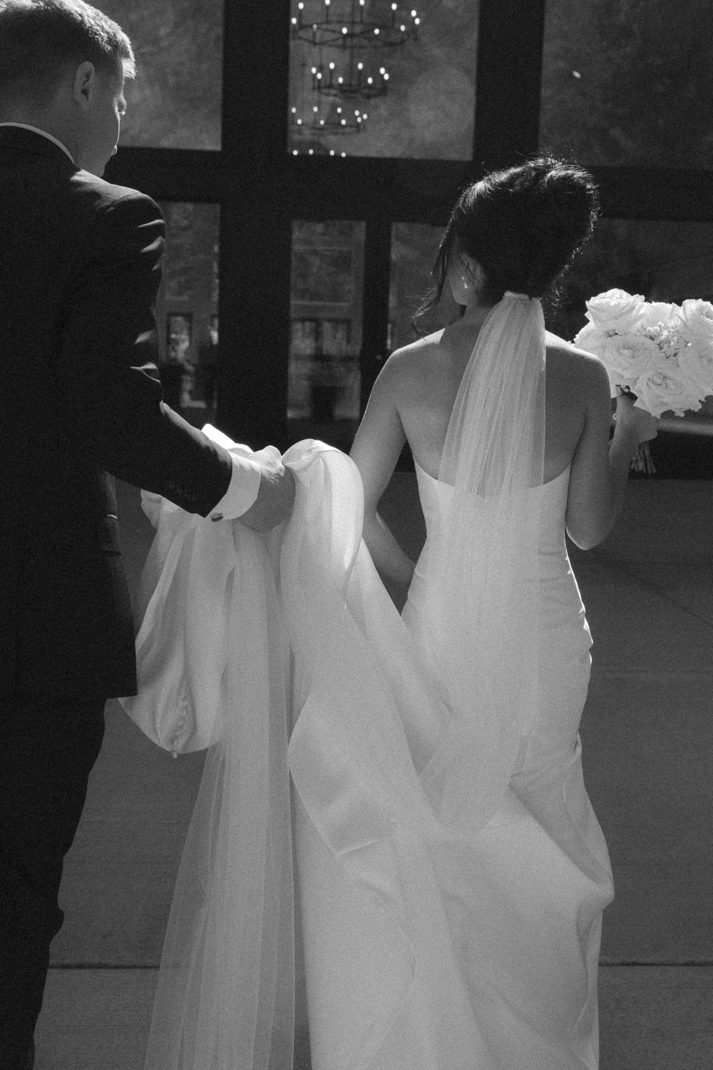 Black and white photo of a wedding dance floor with sparkling lights overhead.