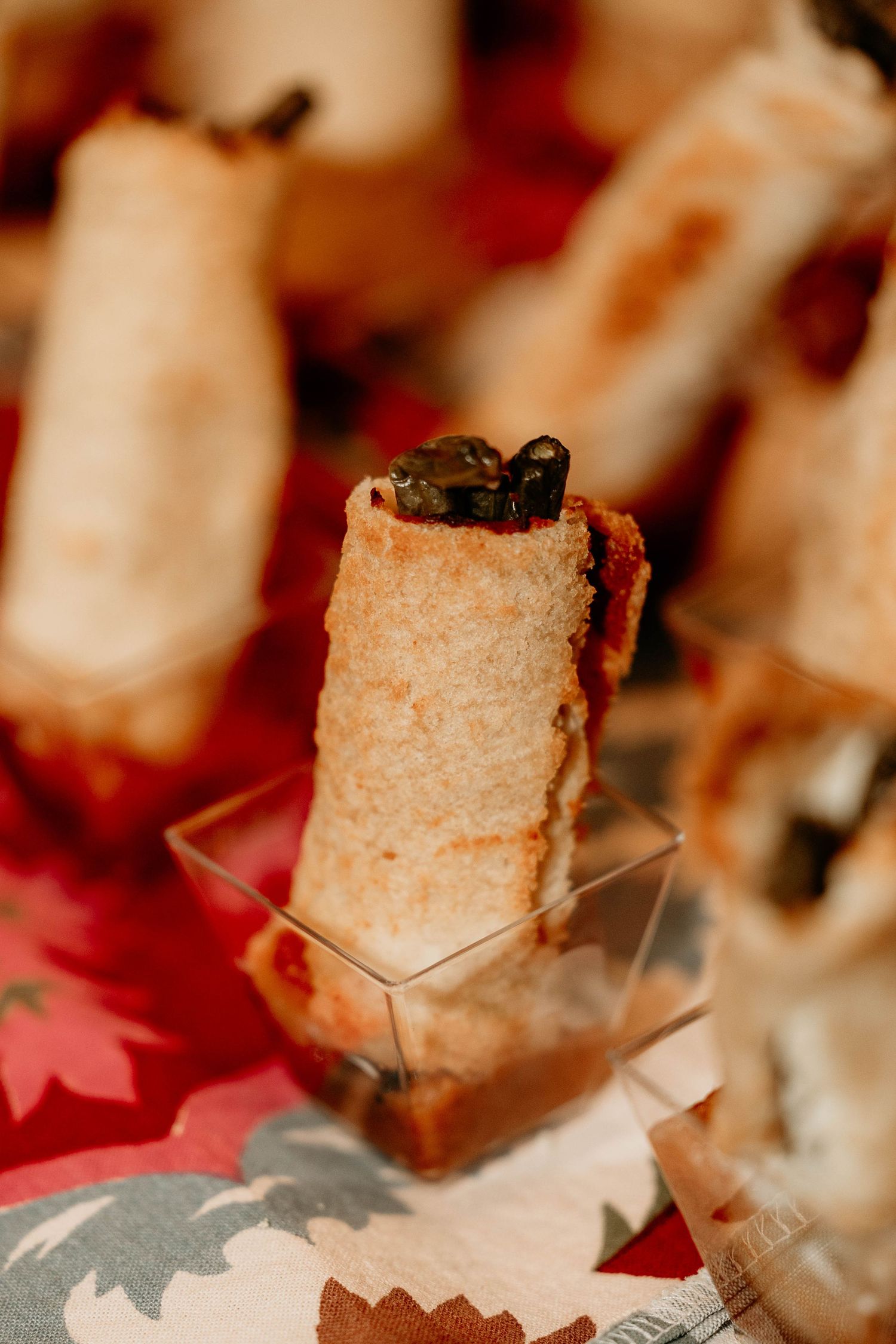 Closeup of toasted bread cubes arranged in a line on a red and white surface.