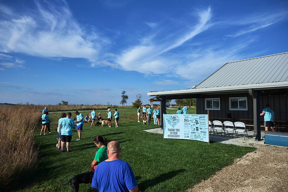 Group of participants gathered at an outdoor event under bright blue skies.