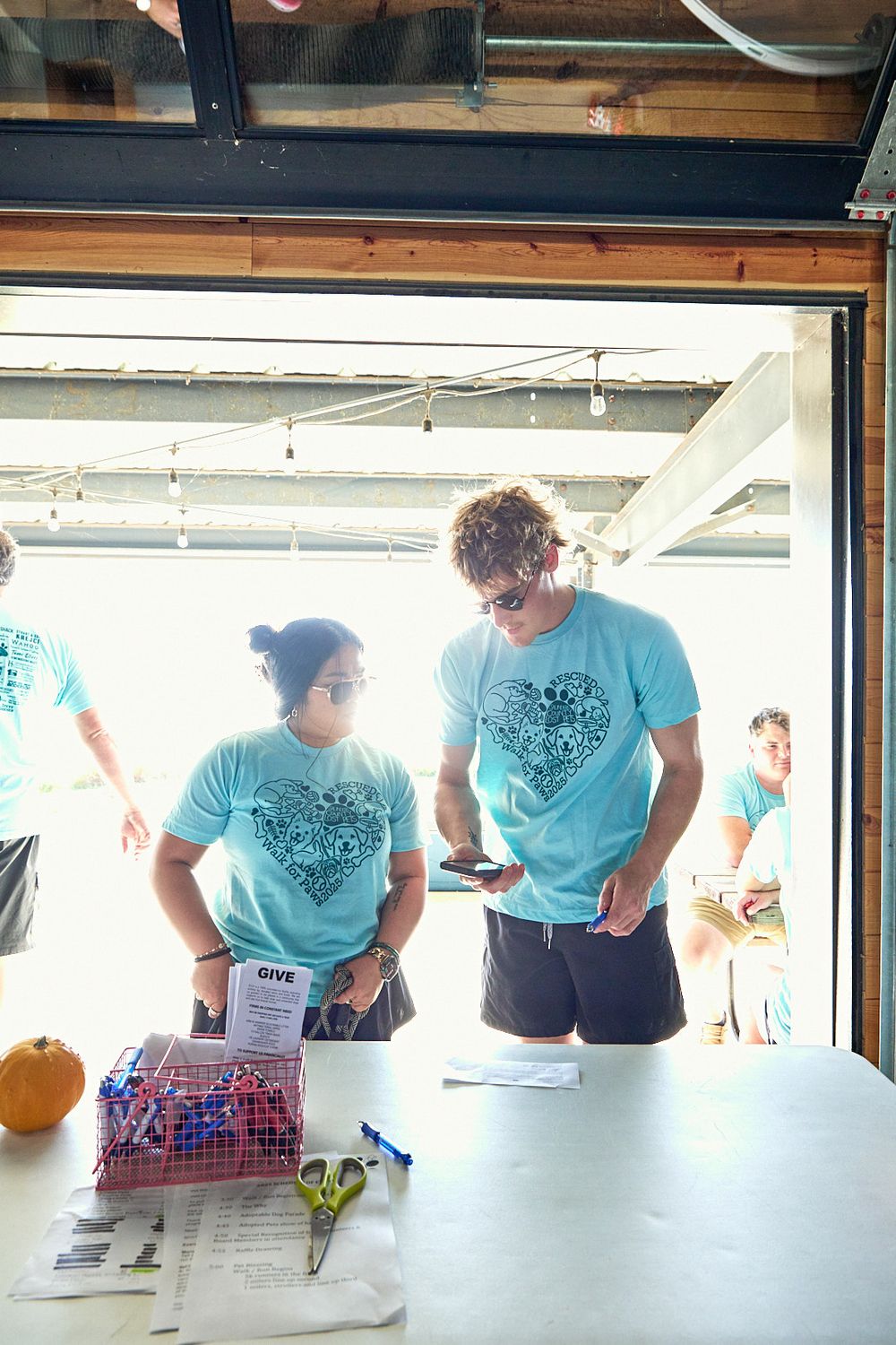 Volunteers in matching light blue t-shirts working at registration tables.