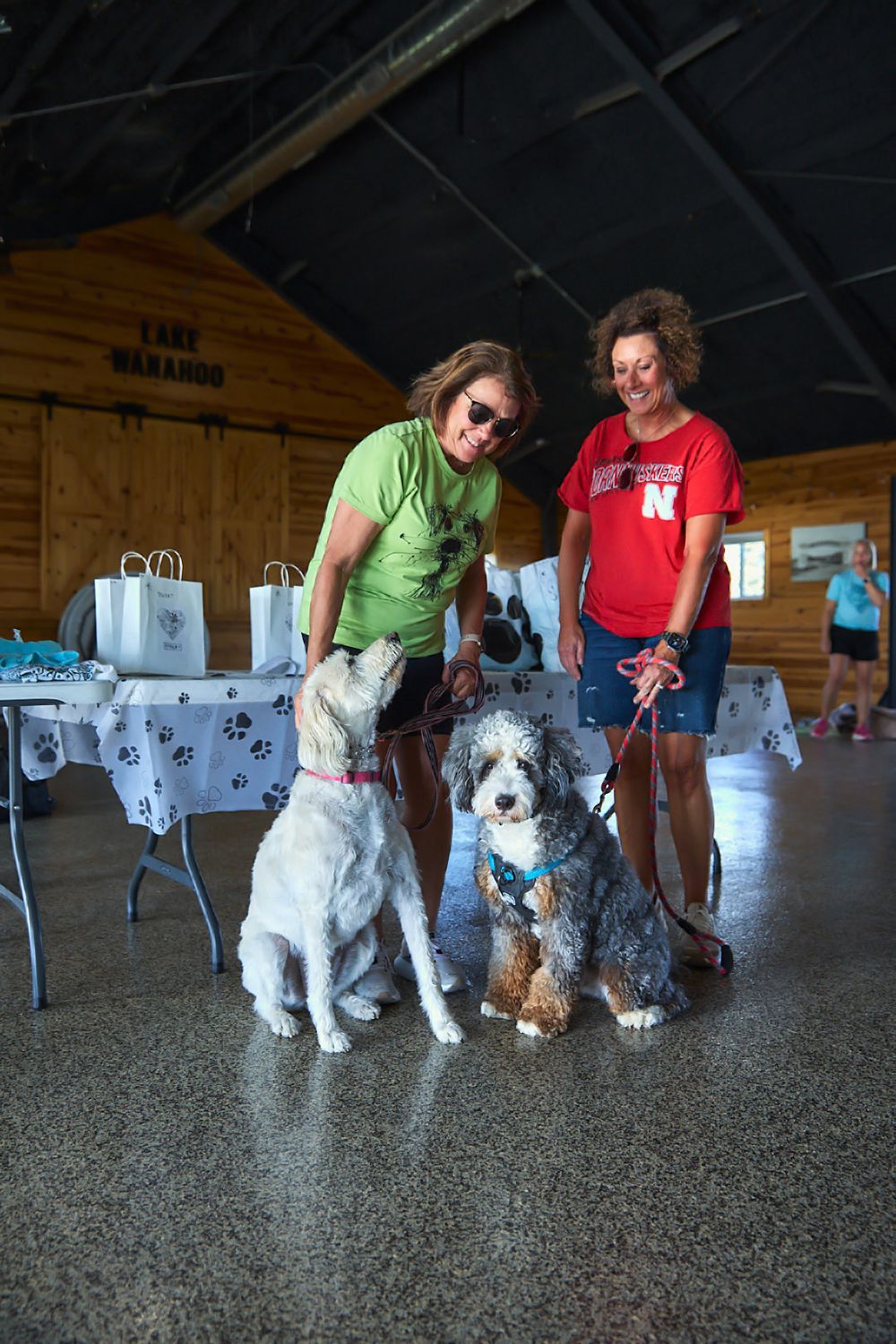Several dogs with their handlers posing together inside a wooden shelter.