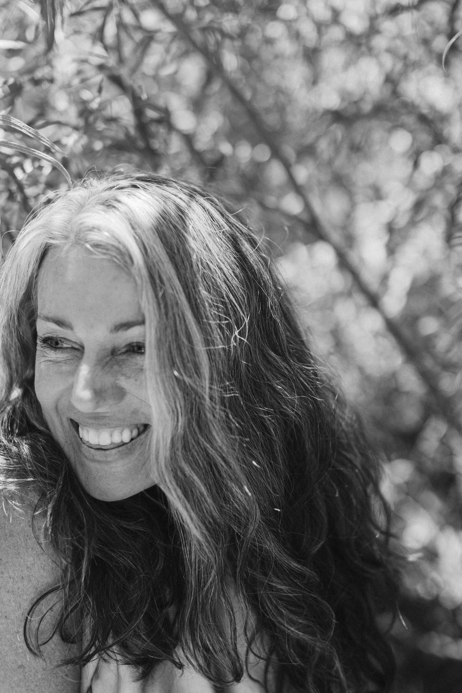 Series of candid black and white portraits showing joyful expressions and flowing hair.