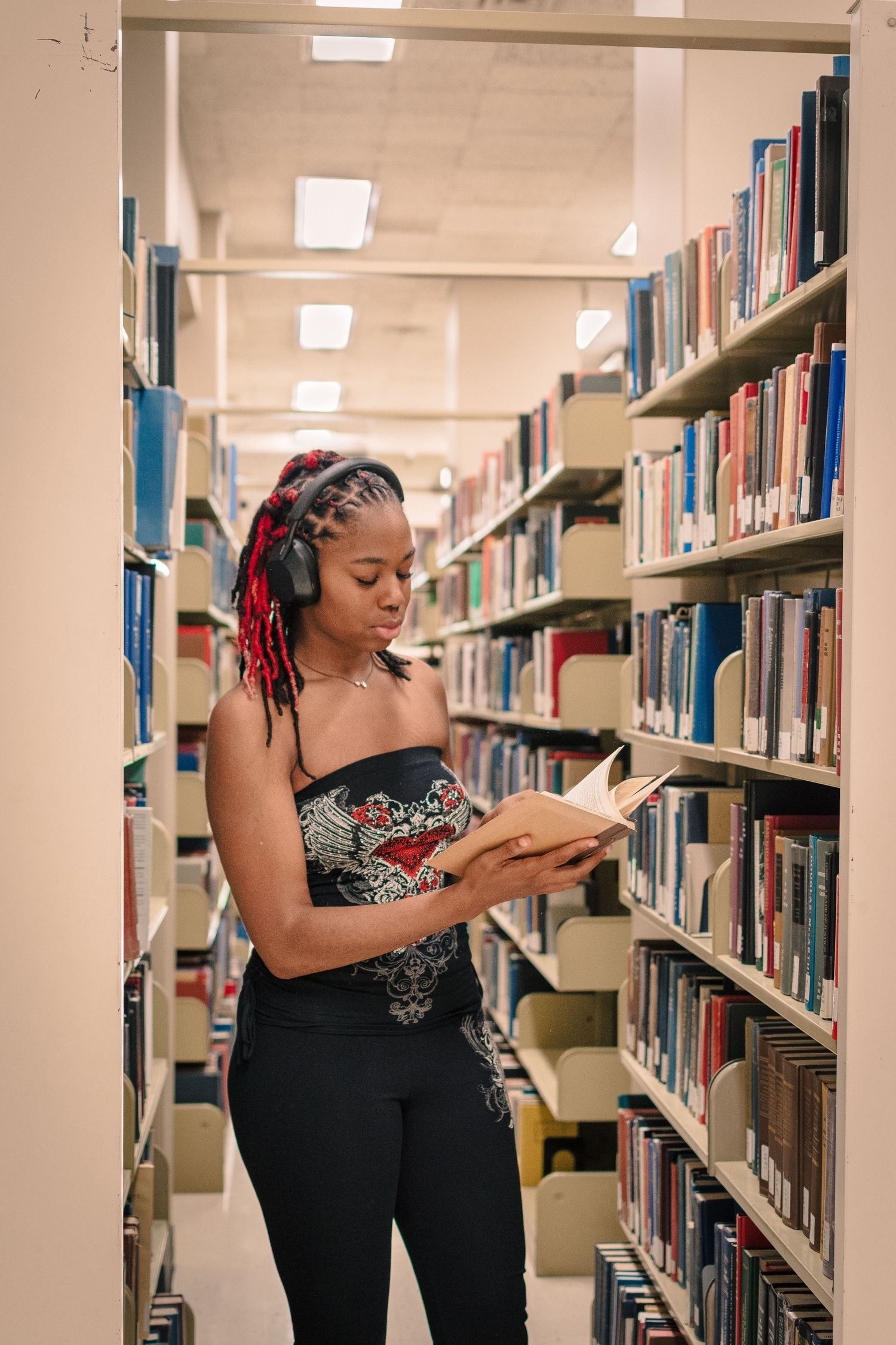 Seattle senior photo between library bookshelves at Suzzallo Library University of Washington