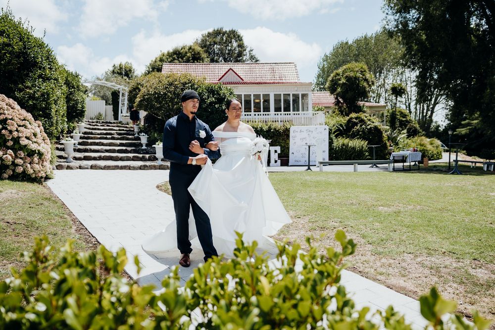 Elegant outdoor wedding venue with white gazebo and seating arrangements nestled among green landscaping.