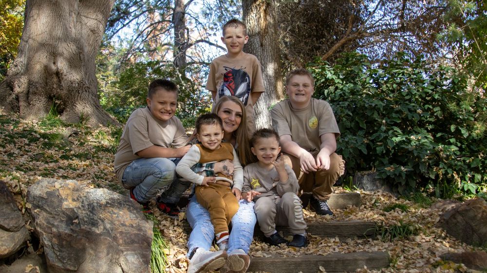 Large family sitting together outdoors during a lifestyle family photography session in Utah