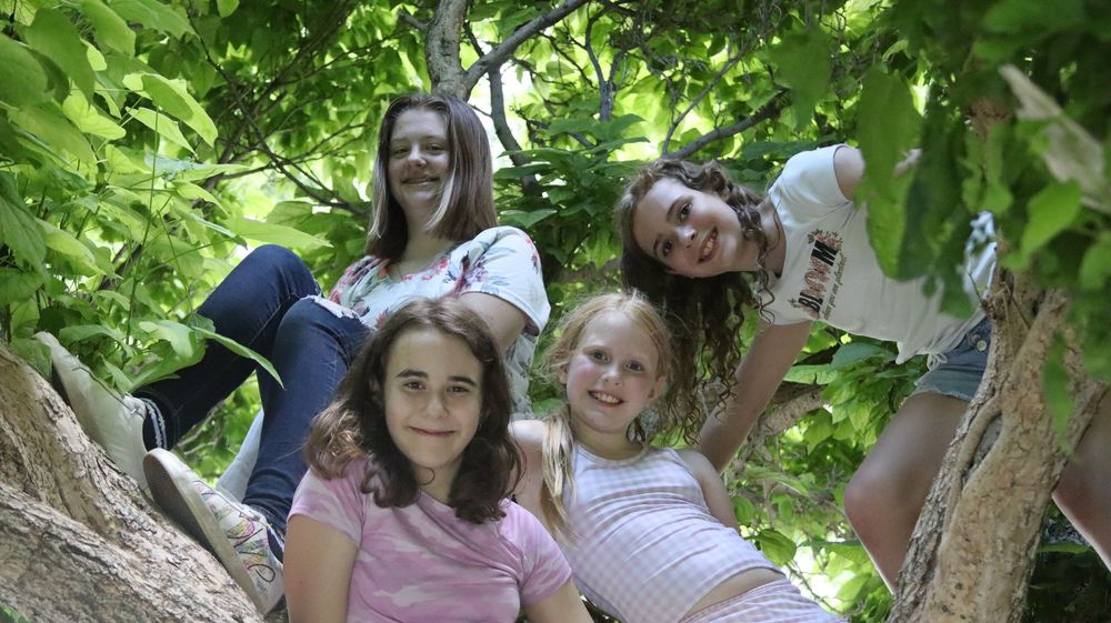 Group of girls smiling together during a candid outdoor family photography session