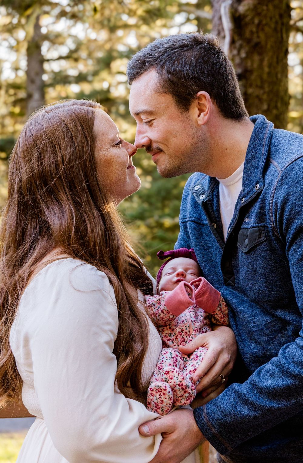 A loving couple shares tender moments with their baby in a series of intimate outdoor family portraits.
