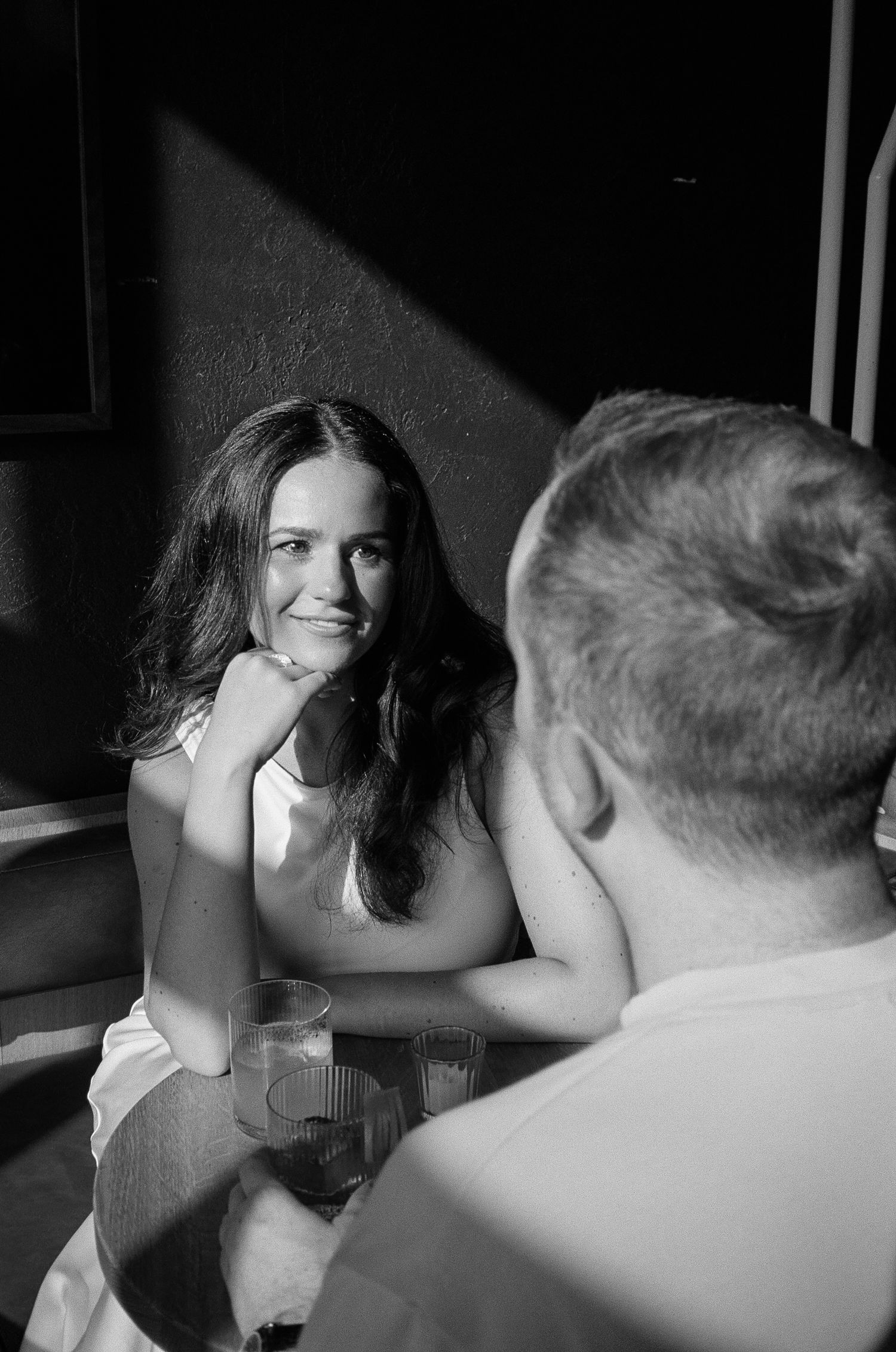 A series of black and white photos showing intimate moments between two people in conversation.