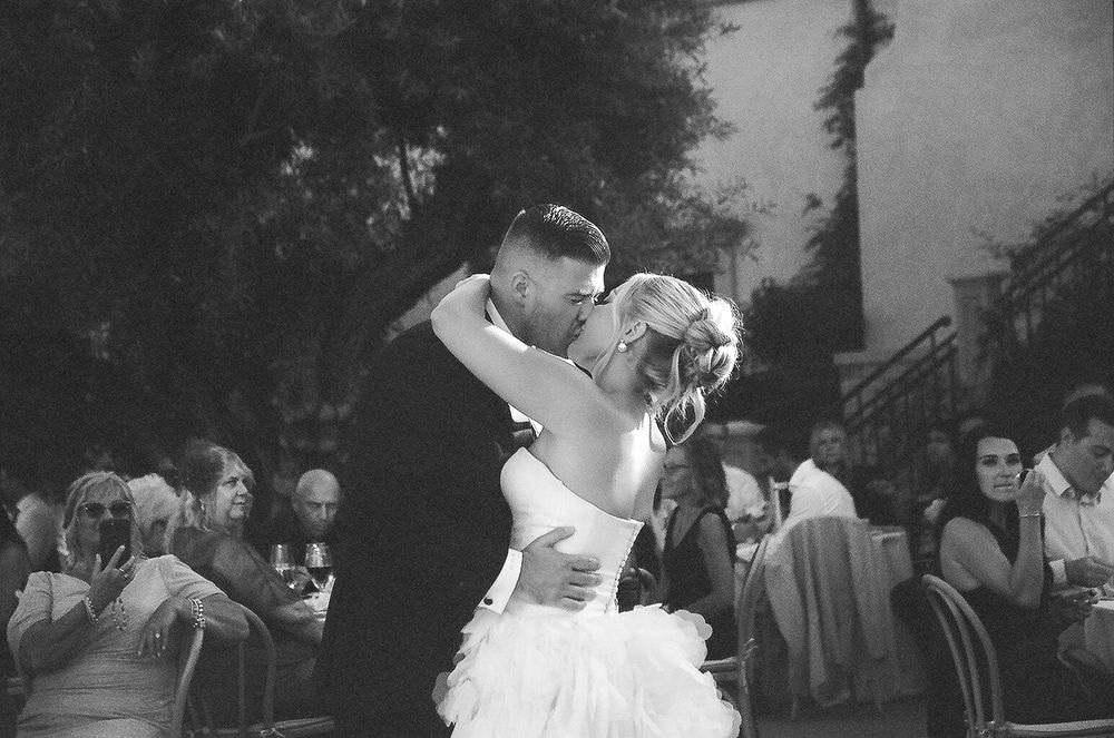 A black and white collage of outdoor wedding moments showing dancing, embraces and candid celebrations.