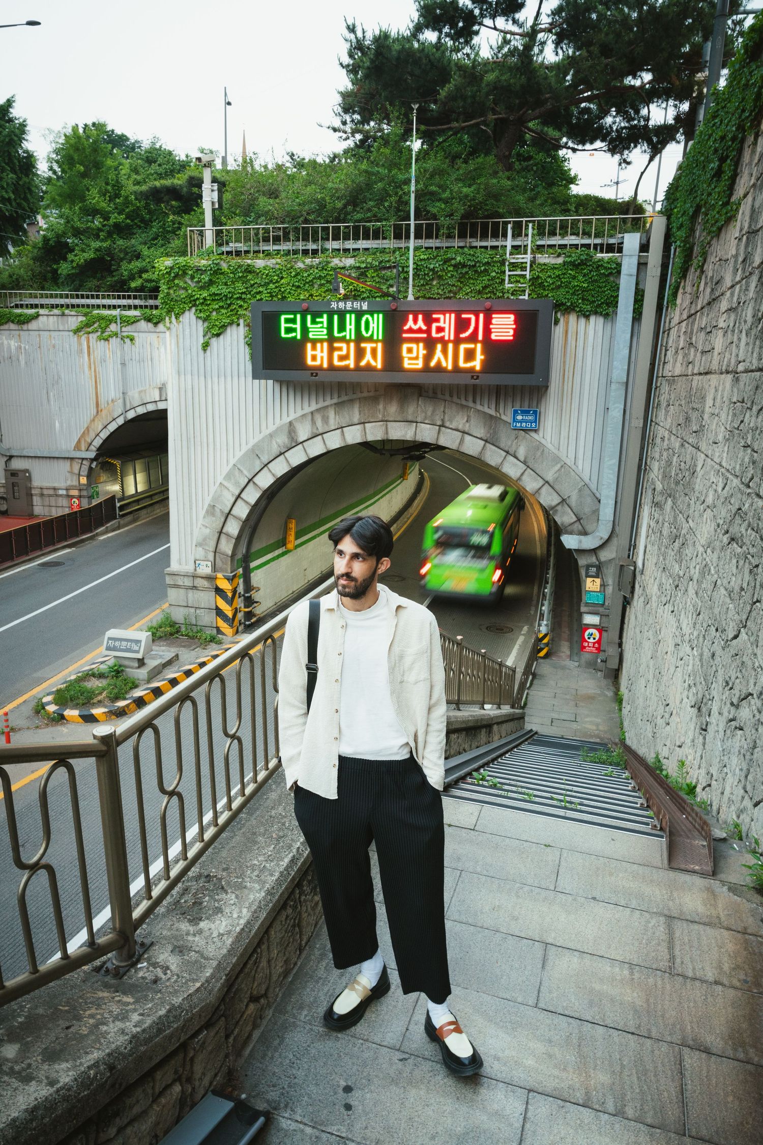 A series of photos showing a person walking down concrete steps near a tunnel entrance in an urban setting.