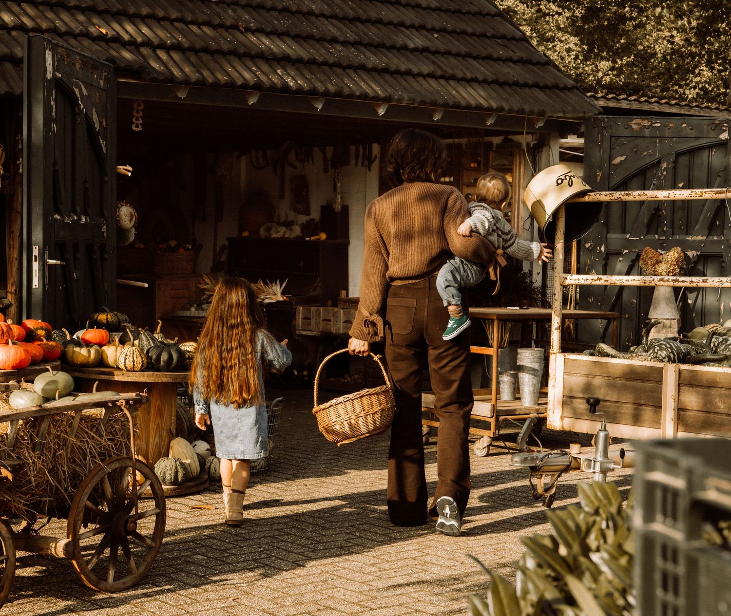 Rustic outdoor market scene with wooden structures and autumn decorations.