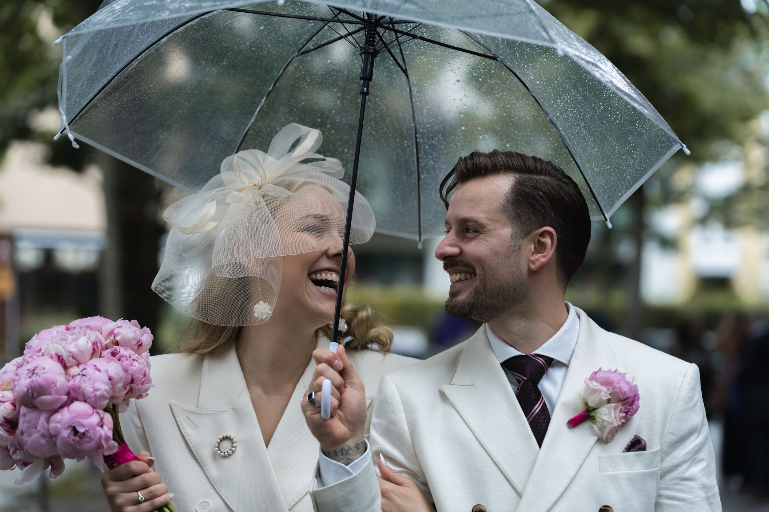 Braut lacht entspannt beim Anziehen – Fokus auf natürliche Hochzeitsfotos und Reportage-Stil.