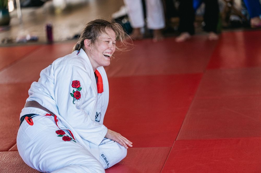 A sequence of judo throws being demonstrated on a red mat during martial arts training.