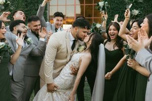 Wedding couple shares a romantic moment on the dance floor surrounded by celebrating guests at an outdoor reception.