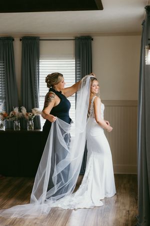 A sequence of four photos showing a bride twirling in her white wedding gown and veil against a room with teal curtains.