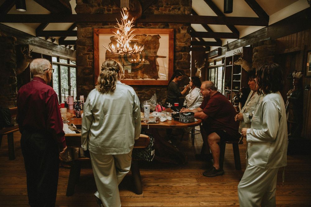 Couples dancing together at a rustic wedding reception venue with wooden beams and warm lighting.