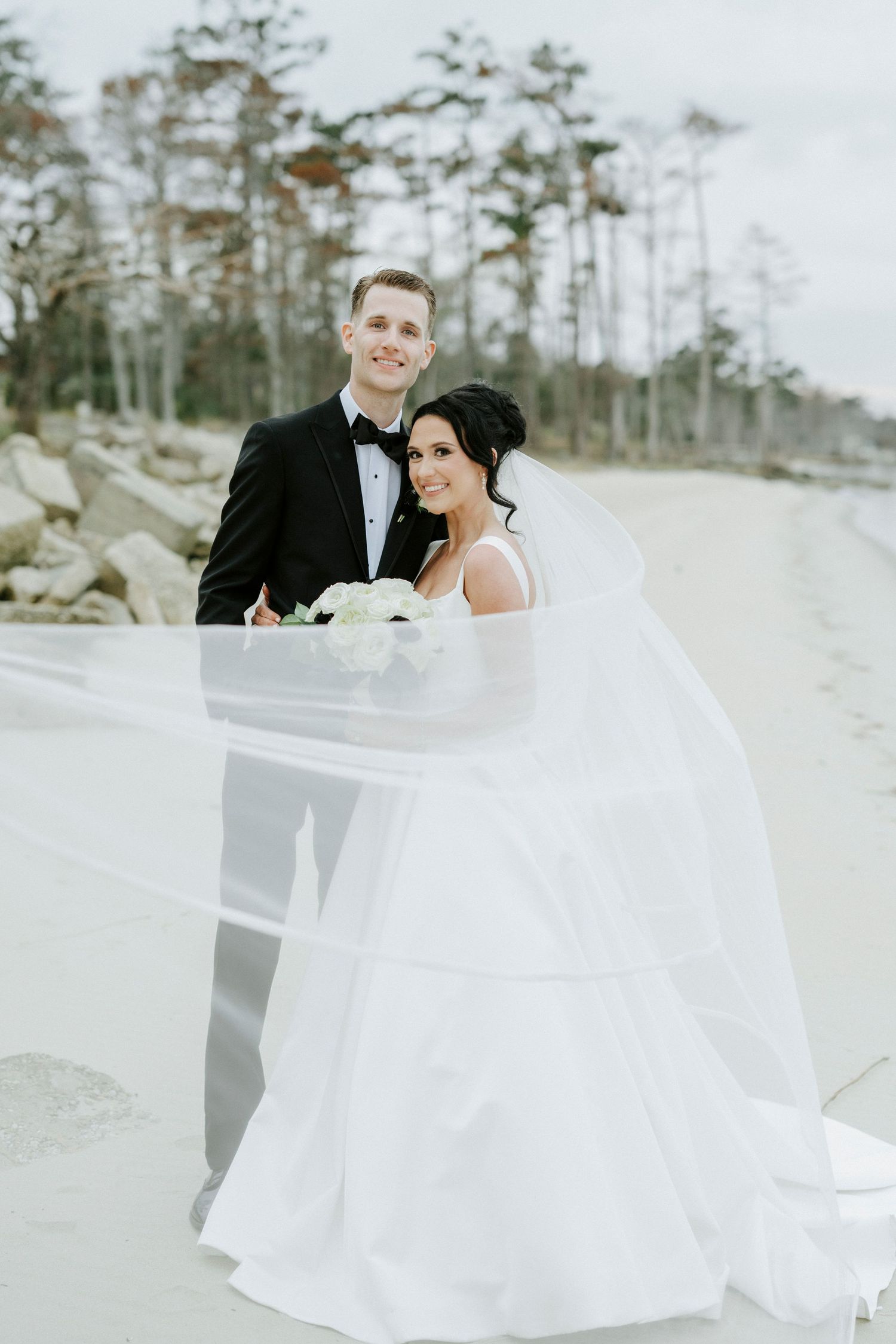 A romantic winter wedding photoshoot with a flowing white dress against a snowy outdoor backdrop.
